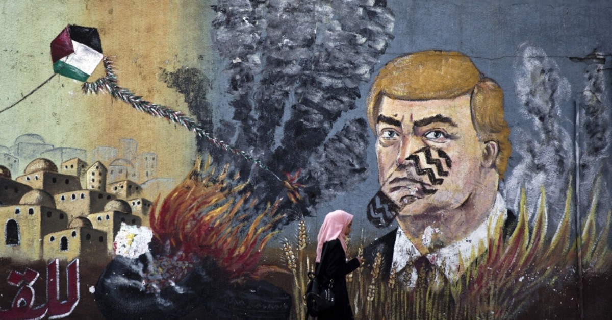 A wall with graffiti depicts U.S. President Donald Trump with a footprint on his face in Gaza City, Tuesday, June 25, 2019.