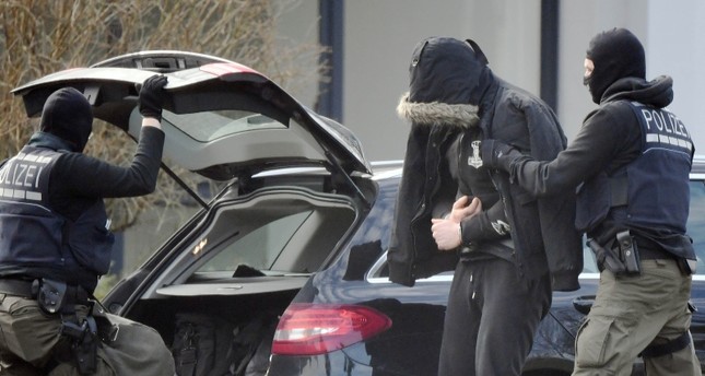 Photo shows police officers bringing a man believed to be one of the 12 men arrested a day earlier in a nationwide probe into an extreme-right group at the Federal Supreme Court in Karlsruhe, southern Germany on Feb.15, 2020. AFP Photo