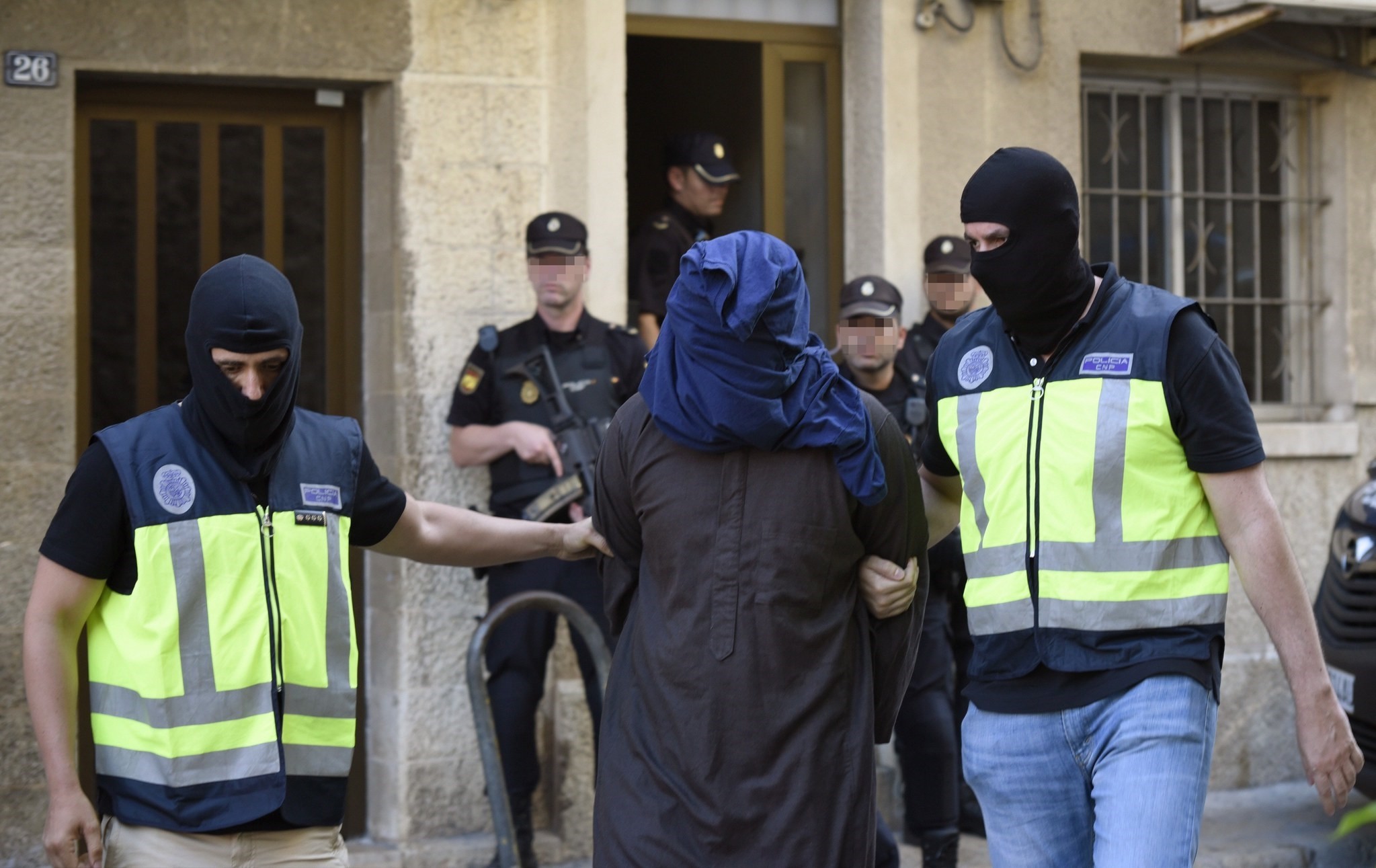 Policemen escort a suspect that was arrested as part of an international anti-terror police operation, in Palma Majorca (EPA Photo)