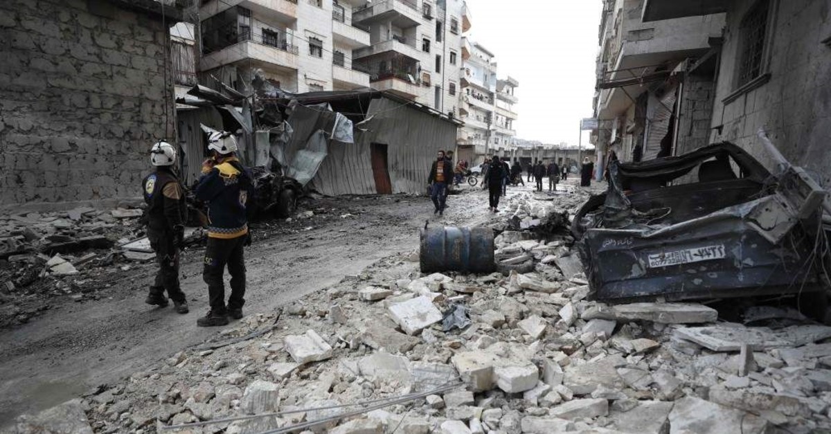 Syrian rescuers known as the White Helmets walk amidst the rubble scattered across a street following a reported regime air strike in the town of Ariha in the Idlib province, Jan. 5, 2020. (AFP PHOTO)