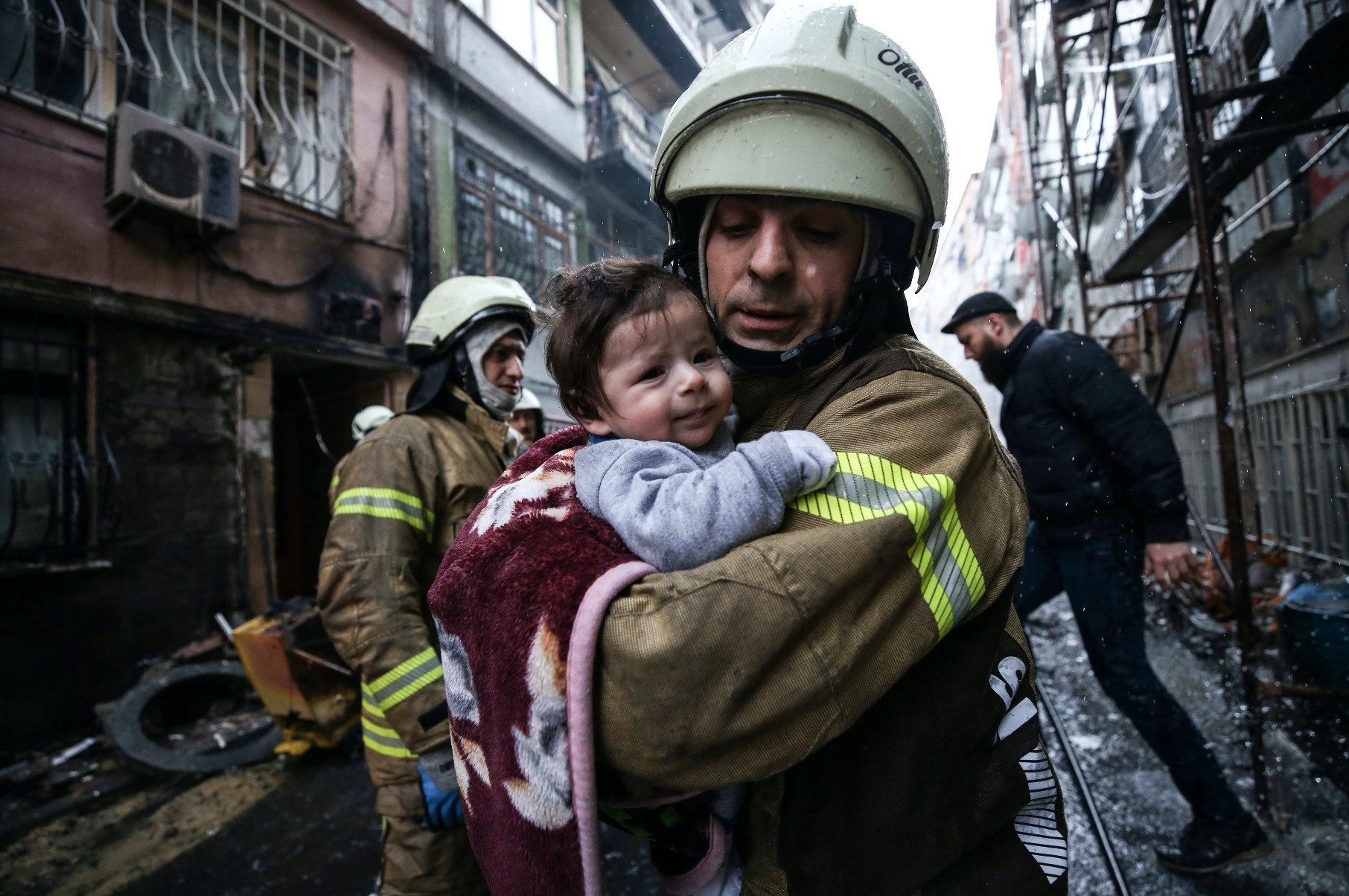 A firefighter saves a baby from house fire due to a natural gas explosion, Fatih, Istanbul.  