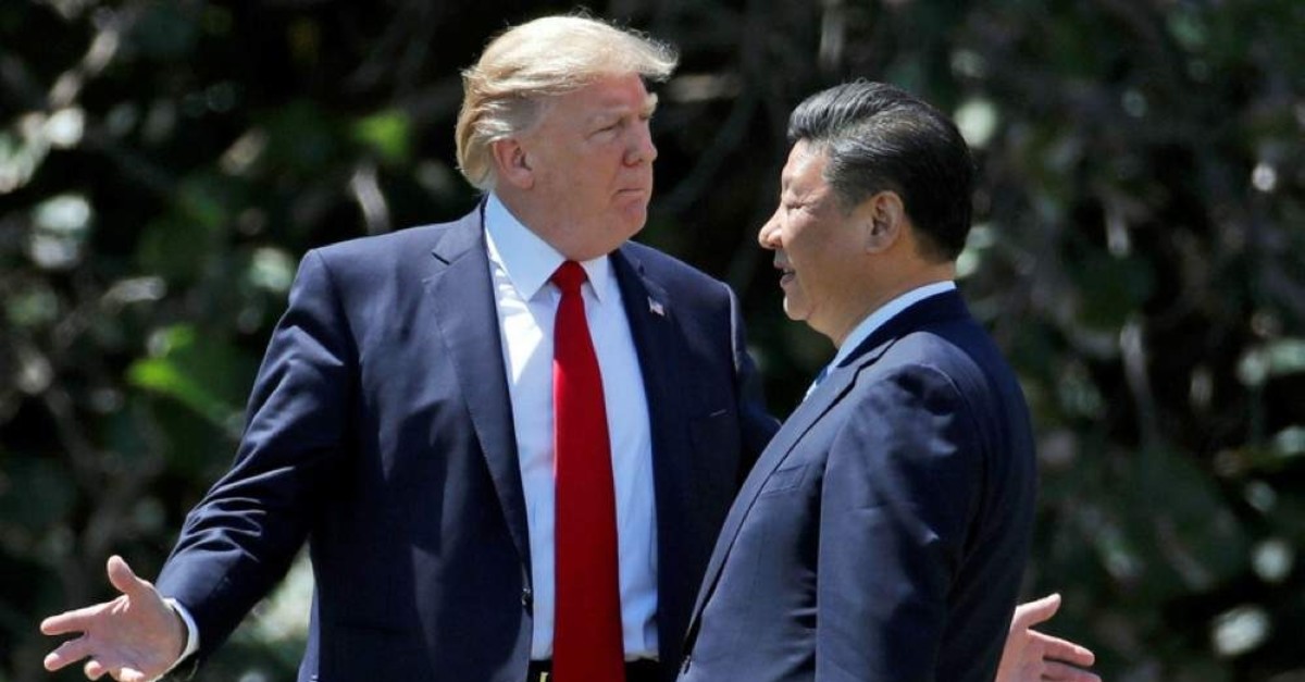 U.S. President Donald Trump, (L) gestures as he and Chinese President Xi Jinping walk together at Mar-a-Lago in Palm Beach on April 7, 2017. (AP Photo)