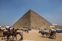 This file photo taken on August 31, 2016 shows Egyptians riding their carts past the Great Pyramid of Cheops, aka Pyramid of Khufu (AFP Photo)