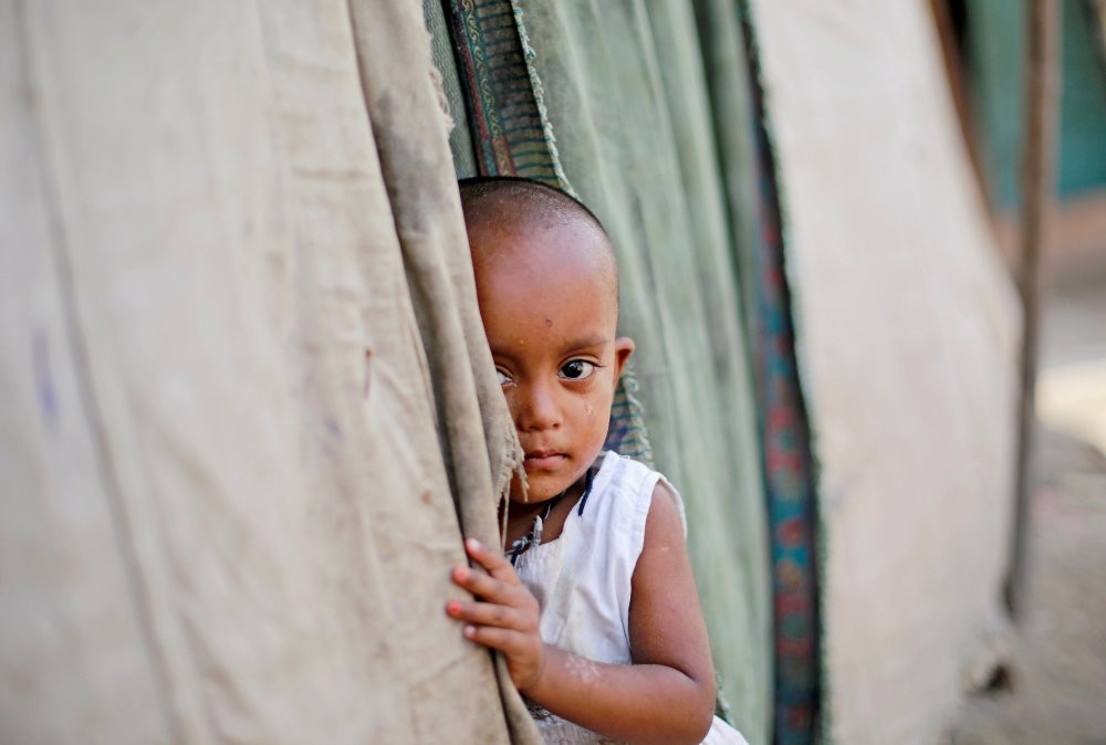 A girl from the Rohingya community stands outside her family's shack in a camp in New Delhi, Oct. 4, 2018.