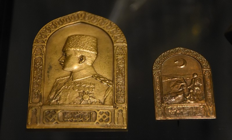 An embossment from WWI with the silhouette of Enver Pasha (on the left), and another embossment depicting an Ottoman soldier and a star and crescent (on the right).