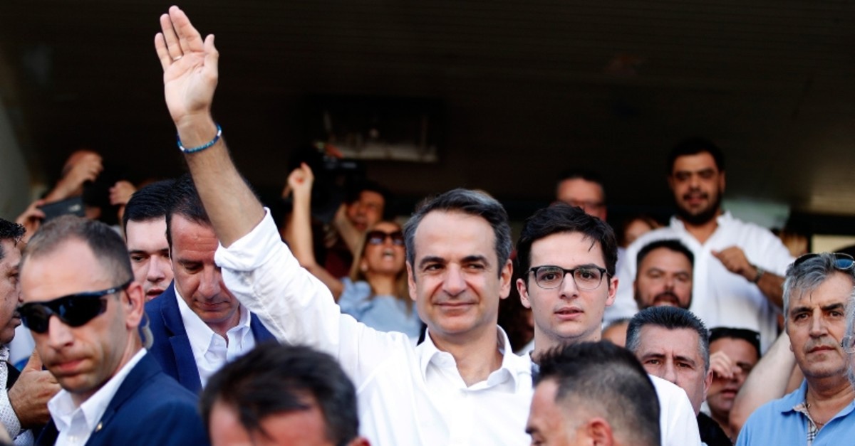 Greek opposition New Democracy conservative party leader Kyriakos Mitsotakis waves to his supporters outside of a polling station in Athens, on Sunday, July 7, 2019. (AP Photo)