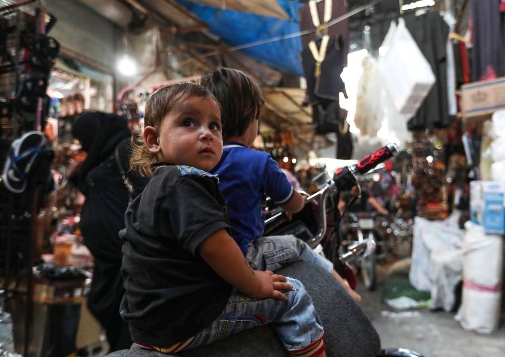 Syrian children sit on a motorcycle at a market in the opposition-held Idlib province, Sept. 27.