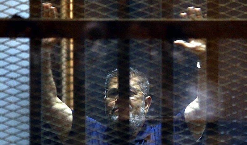 A file photo dated 02 June 2015 shows ousted Egyptian President, Mohamed Morsi gesturing from inside a cage in the courtroom where he stood trial in Cairo, Egypt (EPA File Photo)