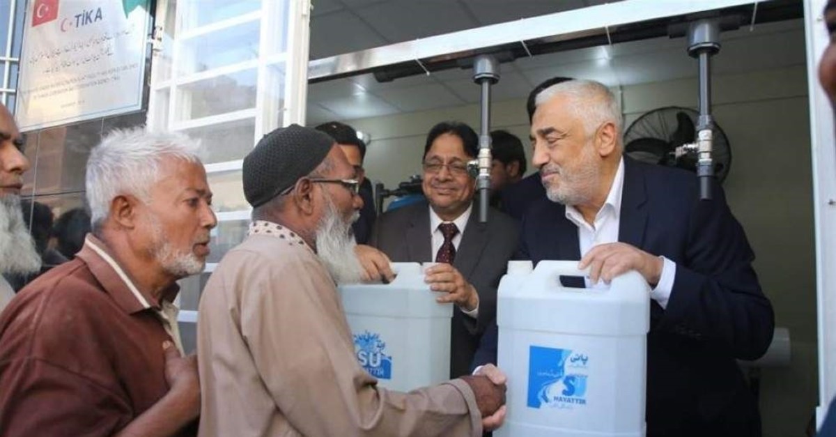 TIKA officials handing out bottles of filtered water to Pakistanis, Sindh, Pakistan. (AA Photo)