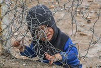 A child sits behind a barbed wire fence in al-Hol camp, which houses former Daesh terrorists, al-Hasakeh, March 28, 2019. (AFP)