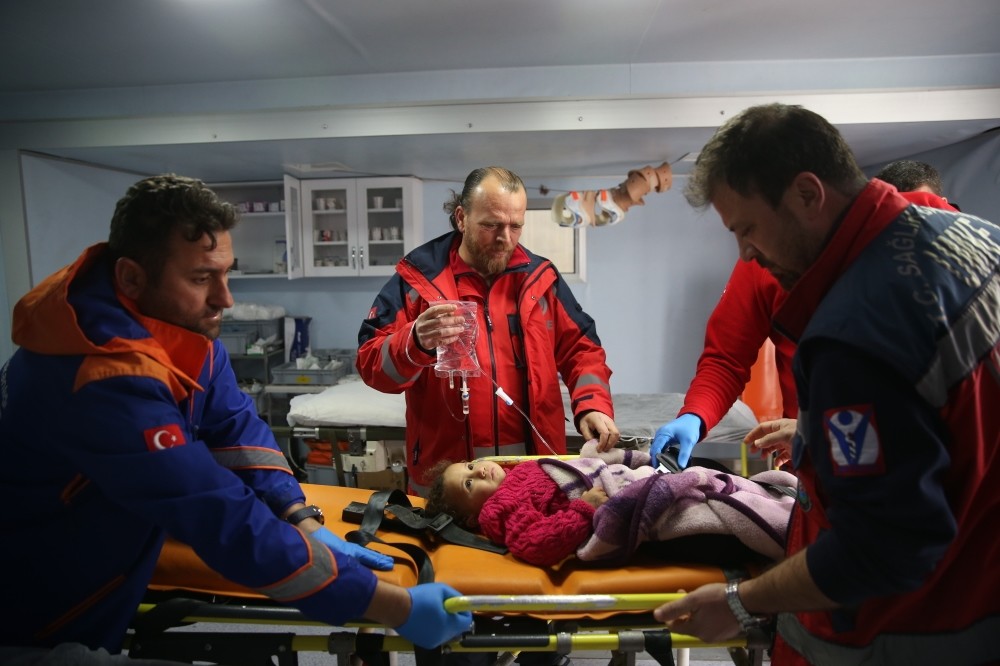 Paramedics attend a sick Syrian child at a clinic near the Turkish-Syrian border.  Along with health services offered at Turkish hospitals, healthcare staff is deployed to the country's border with Syria.