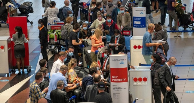 مئات المسافرين يصطفون بمطار أوليفر تامبو بجوهانسبرغ في جنوب إفريقيا لمغادرة البلاد بعد الإعلان عن السلالة المتحورة الجديدة من فيروس كورونا أسوسييتد برس
