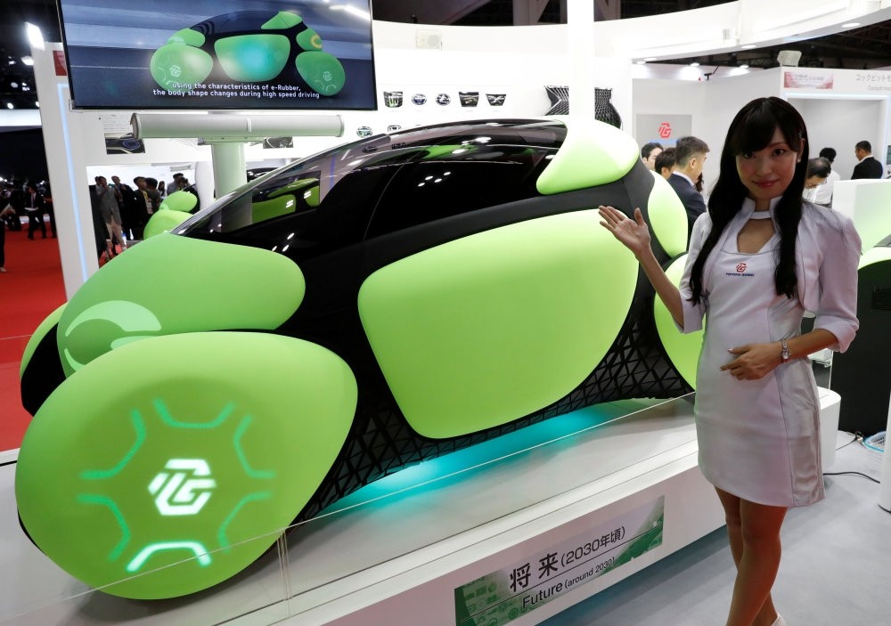 A model presents the Flesby, a one-seater mobility concept car exhibited by Japan's auto parts maker Toyoda Gosei, during a media preview of the 45th Tokyo Motor Show.