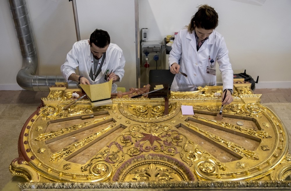 Restorers work on a piece with gold leafs from a bed belonging to Sultan Abdu00fclaziz in the workshop in Istanbul, Feb. 14, 2019.
