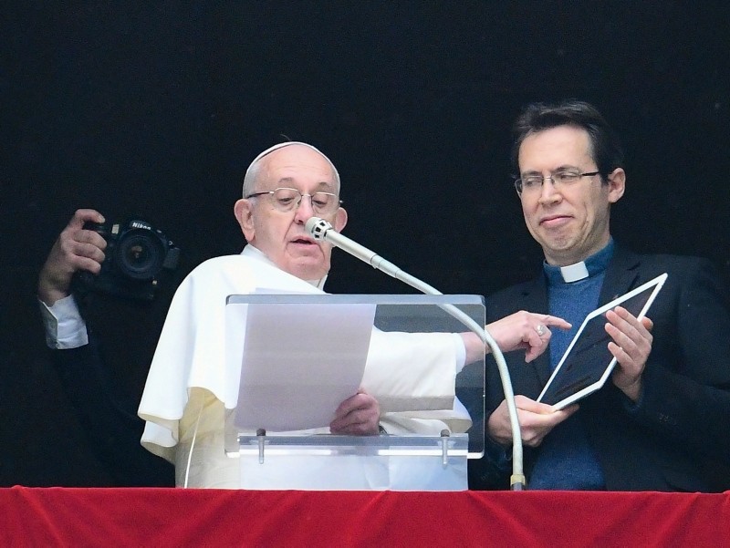 Pope Francis points to a tablet computer as he invites the faithful to download the ,Click to Pray,, from the window of Apostolic Palace overlooking St. Peter's square in the Vatican during the weekly Angelus prayer on January 20, 2019. (AFP Photo)