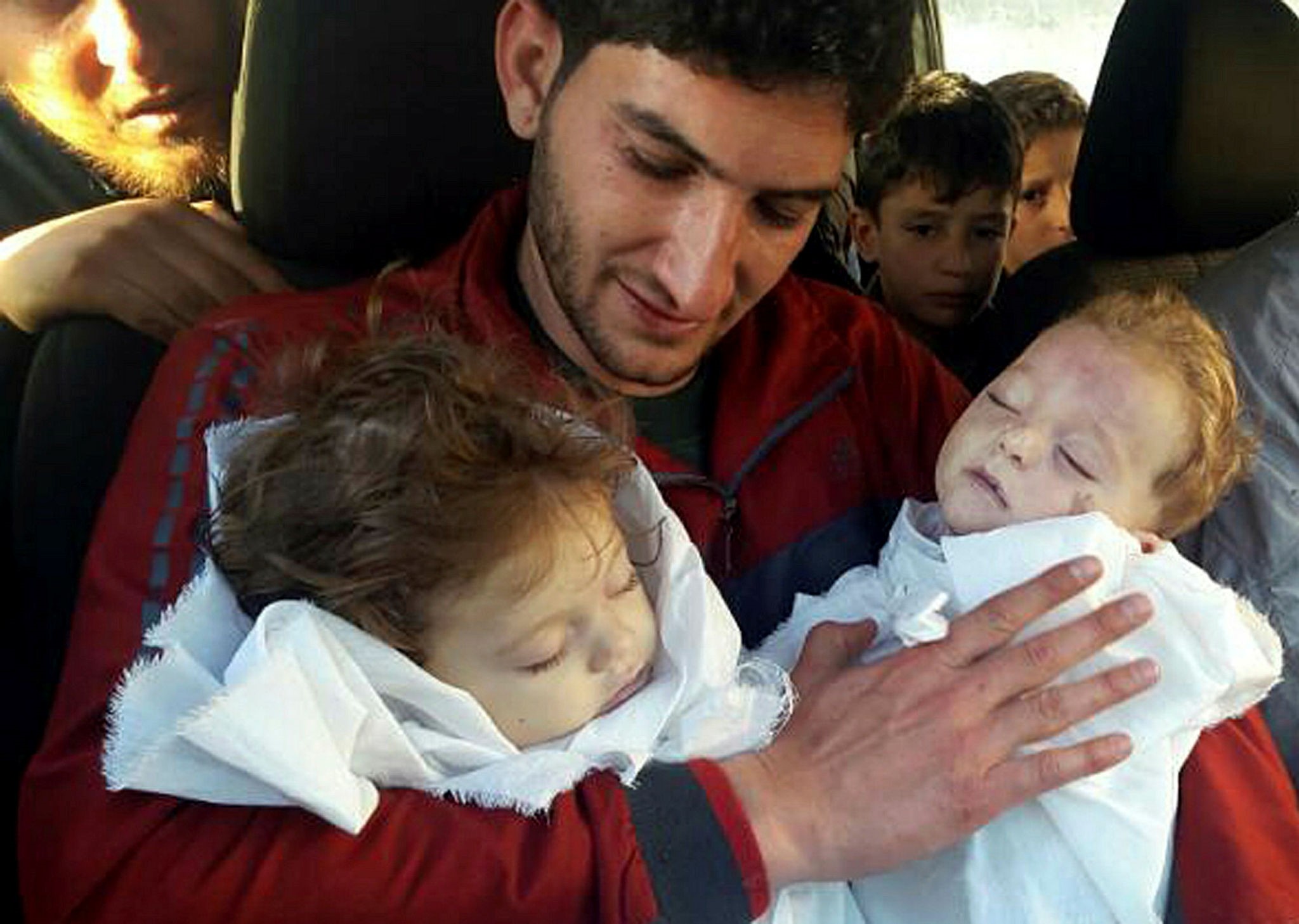 In this picture taken on Tuesday April 4, 2017, Abdul-Hamid Alyousef, 29, holds his twin babies who were killed during an Assad regime chemical weapons attack, in Khan Sheikhoun in the northern province of Idlib, Syria. (AP Photo)