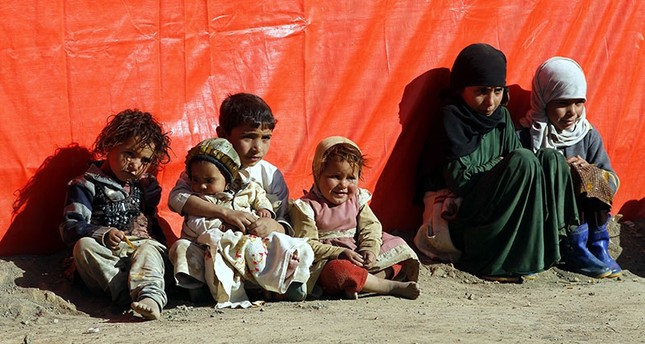 Displaced Yemeni children sit outside a makeshift shelter exposing themselves to the sun light to try and keep them warm at a camp for Internally Displaced Persons (IDPs) in the northern province of Amran, Yemen, Jan. 10 2018. (EPA Photo)