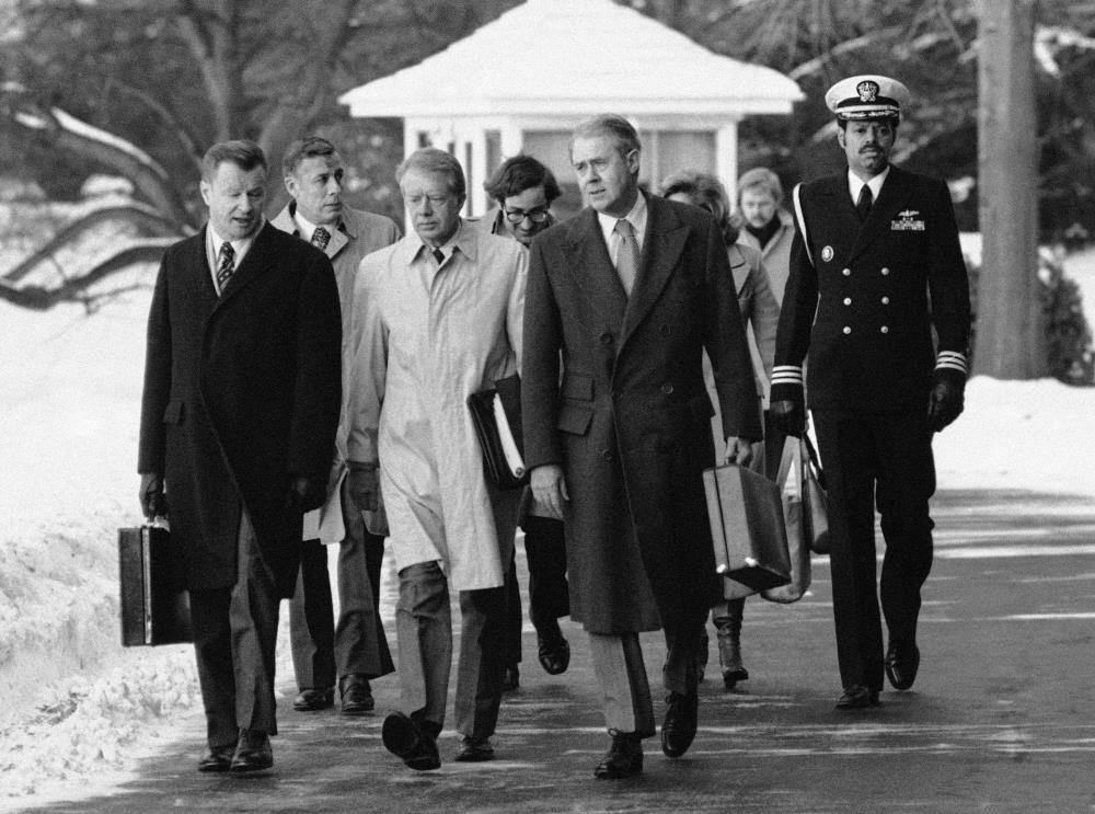 Former U.S. President Jimmy Carter, flanked by Secretary of State Cyrus Roberts Vance, (R) and his adviser on foreign policy,  Zbigniew Brzezinski (L) walking toward a waiting helicopter to fly to the nearby Andrews Air Force Base, Feb. 14, 1979. 