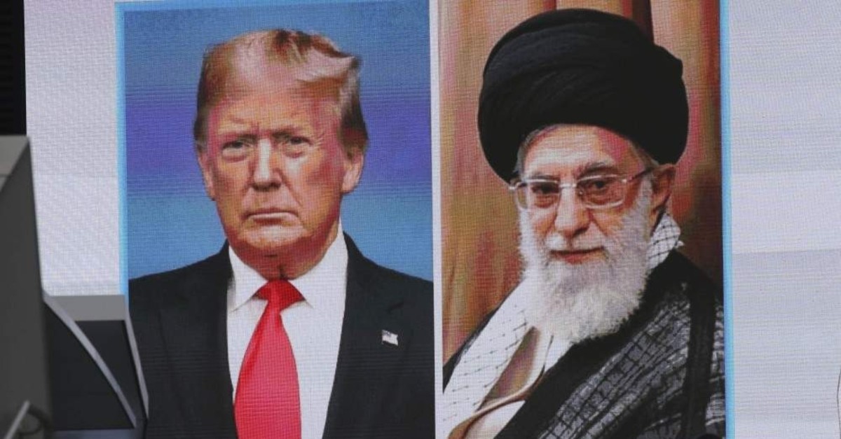 A man walks by a huge screen showing U.S. President Donald Trump (L) and Iranian Supreme Leader Ali Khamenei, Tokyo, Jan. 8, 2020. (AP Photo)