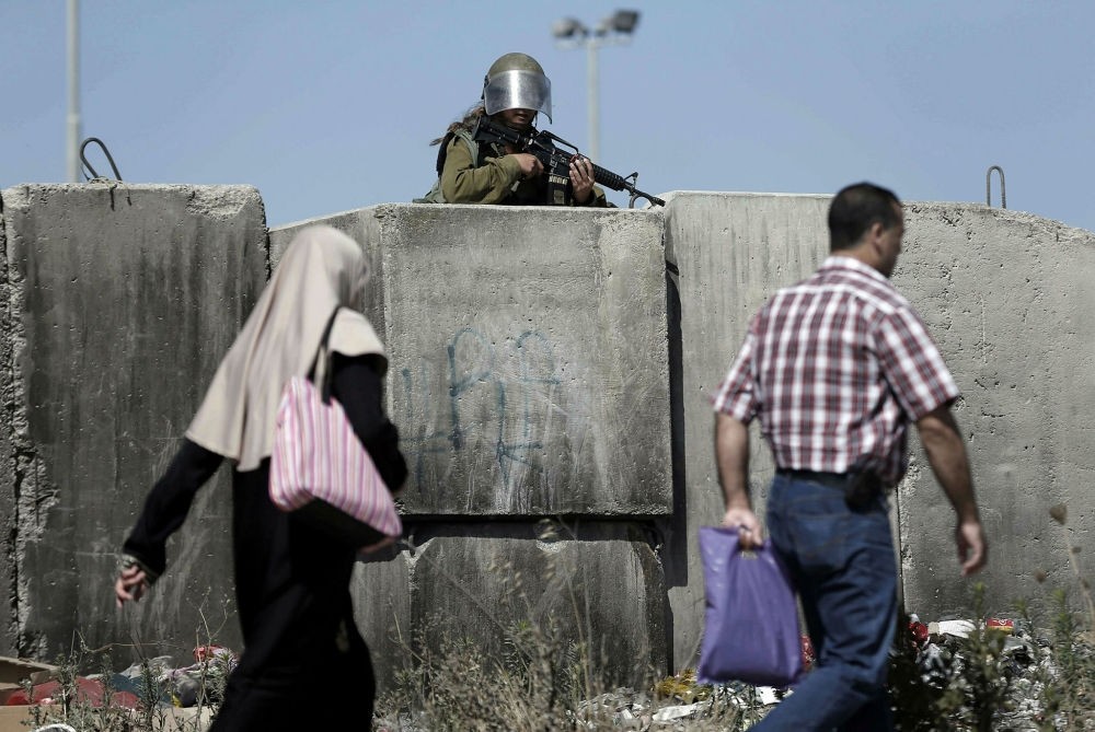 A female Israeli soldier stands guard at the Qalandia checkpoint, south of Ramallah, West Bank.
