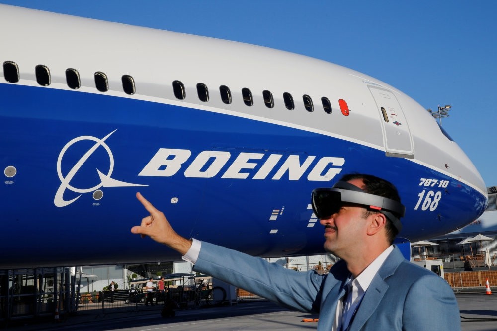 Maziar Farzam, president of Inhance Digital, demonstrates virtual reality glasses which provide digital information about the Boeing 787-10 aircraft, during the opening of the 52nd Paris Air Show at Le Bourget Airport, near Paris.