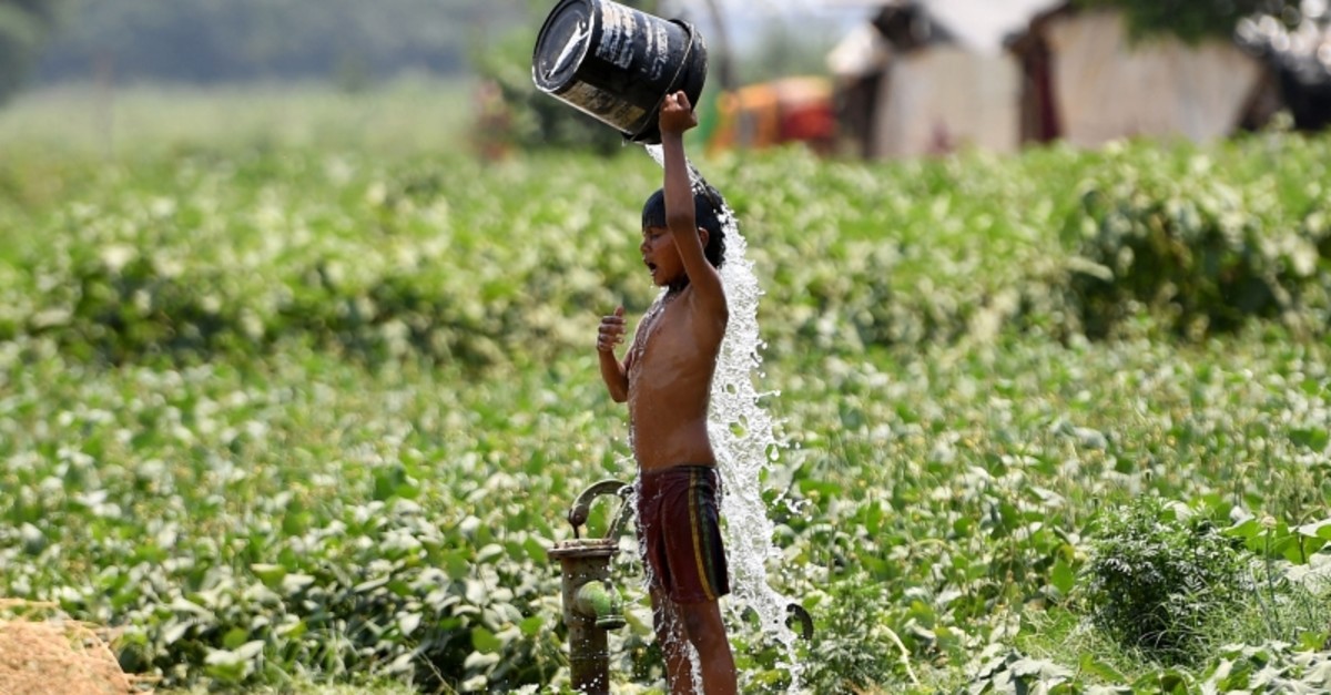 In this file photo taken on May 29, 2019, an Indian boy pours water on himself as he tries to cool himself off amid rising temperatures in New Delhi. (AFP Photo)