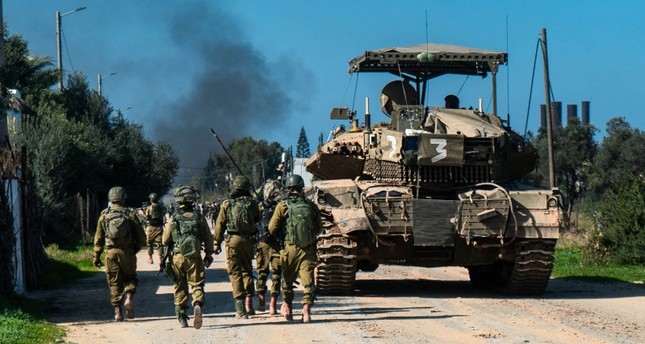 جنود إسرائيليون يسيرون بجانب مركبة عسكرية في قطاع غزة صورة:AFP