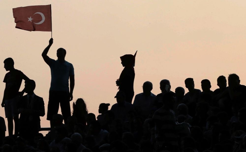 An AK Party supporter waves a Turkish flag during a ceremony to mark the 16th anniversary of their party's foundation, Ankara, Aug. 14. 