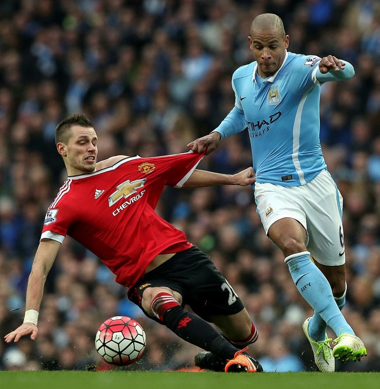 Manchester City's Fernando Reges (R) fights for the ball with Manchester United's Morgan Schneiderlin (L) during the English Premier League soccer match between Manchester City and Manchester United in Manchester, Britain, 20 March 2016.  (EPA Photo)