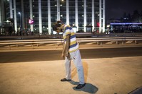 A man stands in a catatonic state on an Istanbul street after consuming bonzai. The drug causes rapid brain damage, with symptoms including schizophrenia-like behavior.