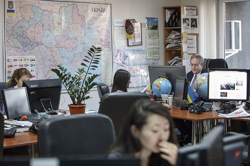 Kyiv Post chief editor Brian Bonner, right, and other journalists work at their desks in Kiev, Ukraine, on Friday, Dec. 8, 2017. (AP Photo)