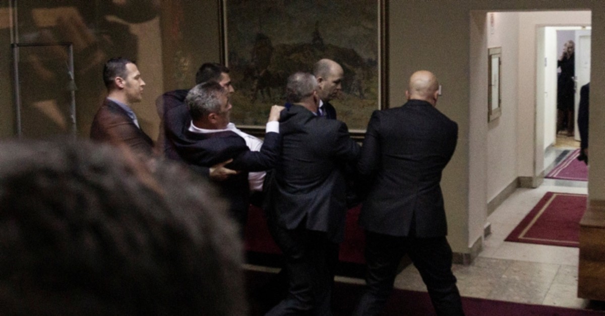 Police officers carry away opposition deputy Slaven Radunovic from the Democratic Front, after they tried to prevent the vote on a bill on religious freedoms & legal rights of religious organizations in Montenegro's parliament in Podgorica (Reuters)
