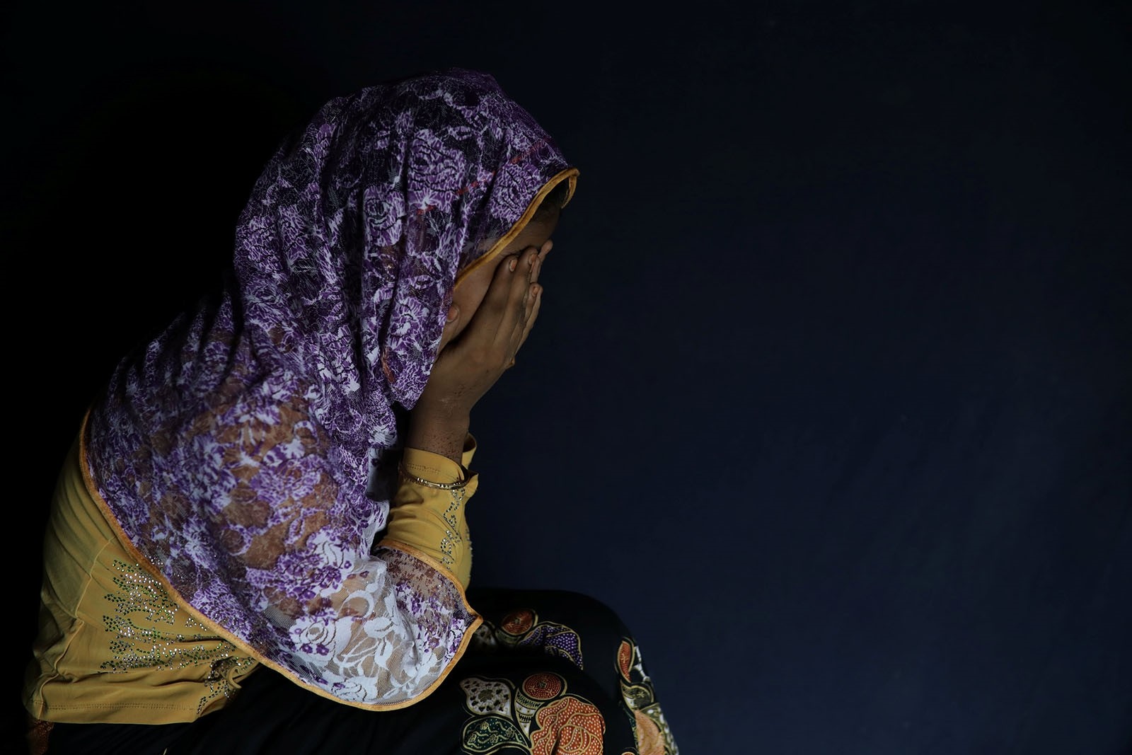 Begum, a Rohingya rape victim, hides her face as she poses in Teknaf, Bangladesh, June 25, 2018.