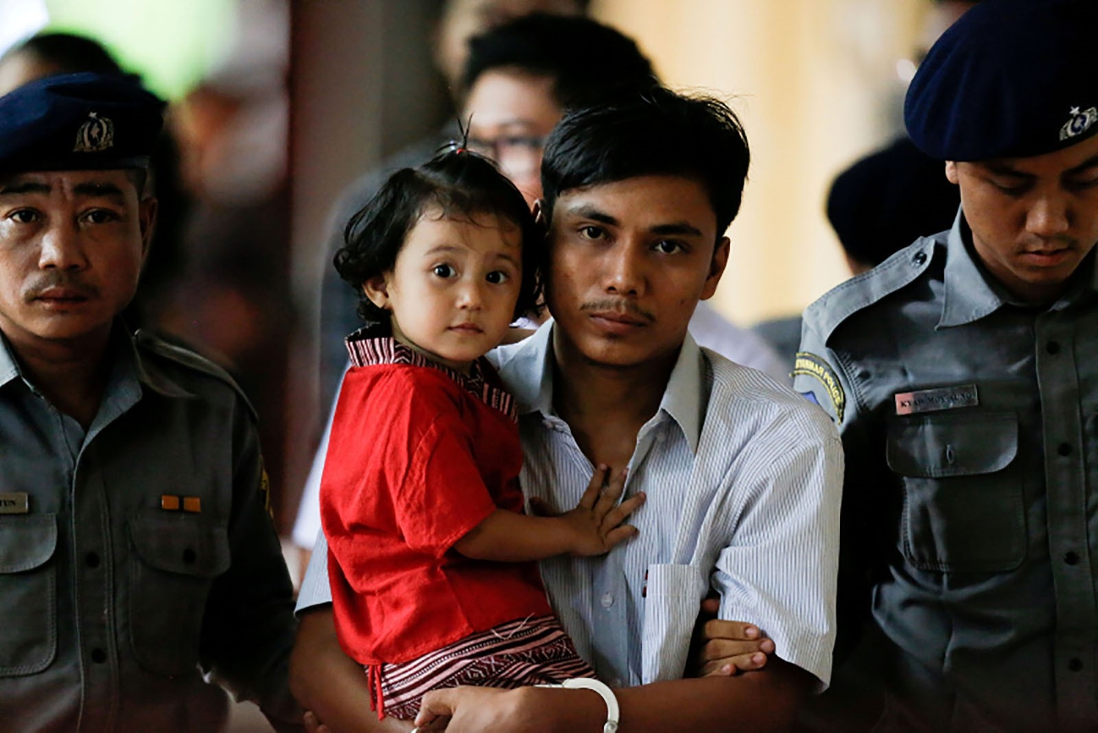 Detained Reuters journalist Kyaw Soe Oo carries his daughter Moe Thin Wai Zin while escorted by police during a court hearing in Yangon, Myanmar, June 5, 2018.