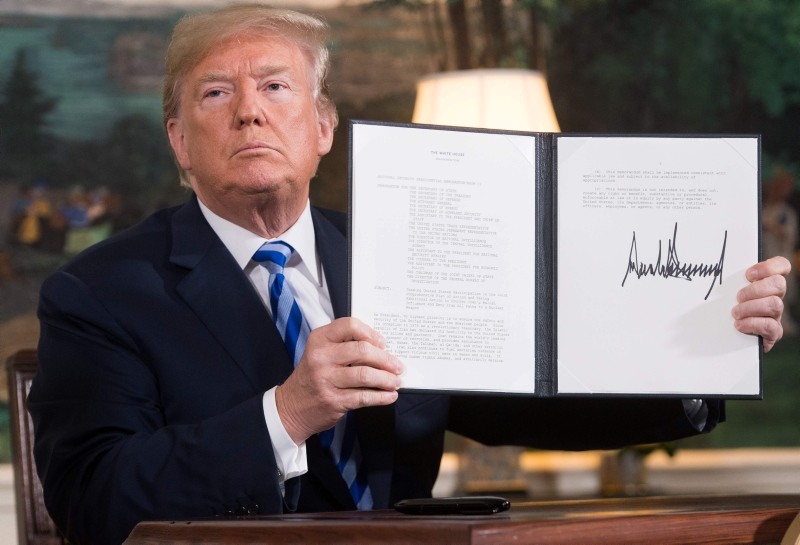 In this file photo taken on May 8, 2018 Trump signs a document reinstating sanctions against Iran after announcing the US withdrawal from the Iran Nuclear deal, in the Diplomatic Reception Room at the White House in Washington. (AFP Photo)