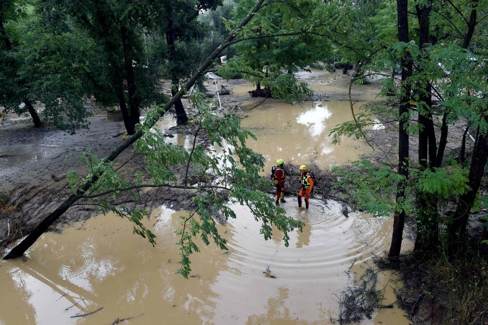 Rescuers stand in a flooded camping site, Saint-Julien-de-Peyrolas, Aug. 9.