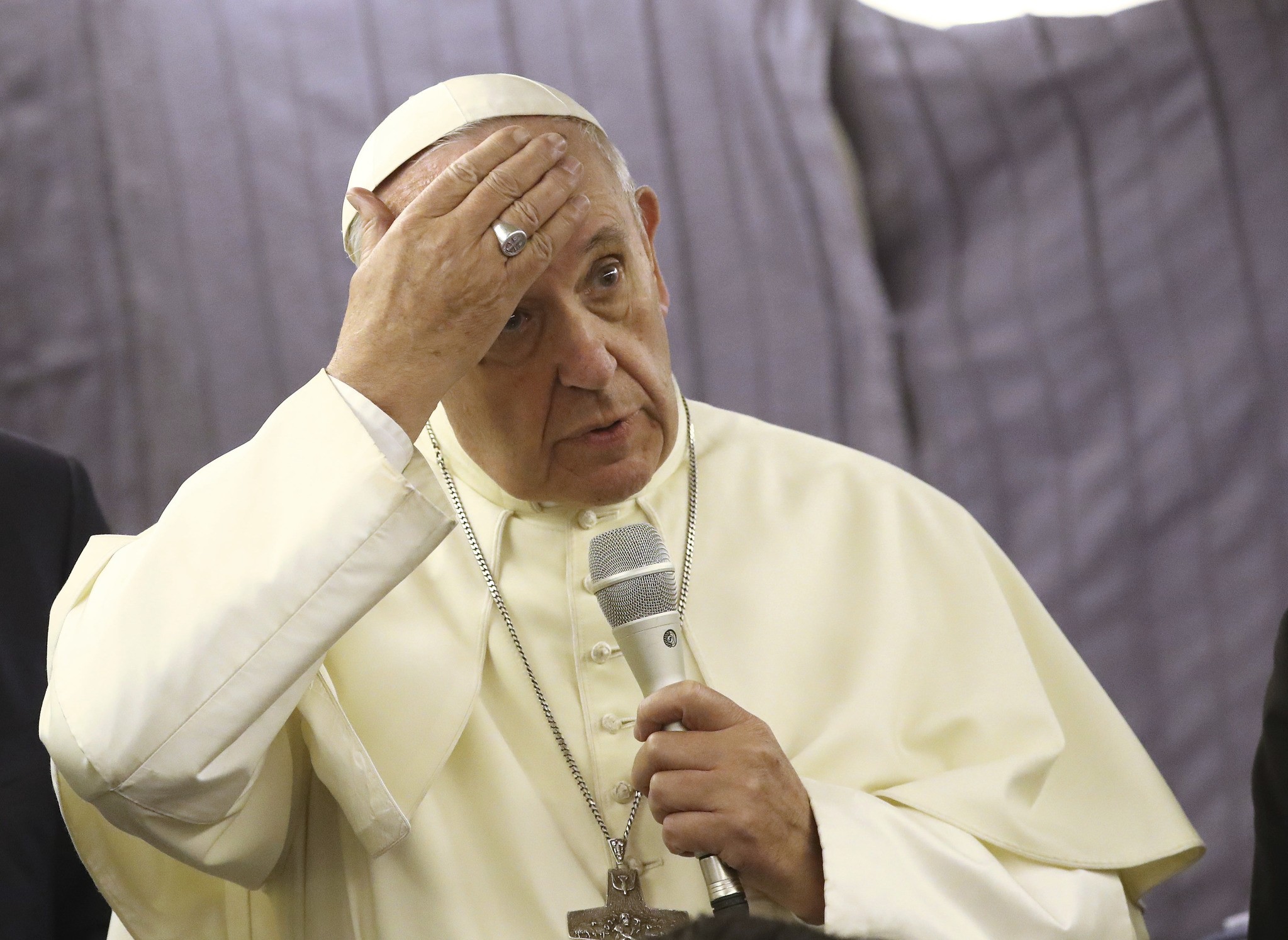 Pope Francis touches his forehead as he talks with journalists during his flight from Lima, Peru, to Rome, Sunday, Jan. 21, 2018. (AP Photo)