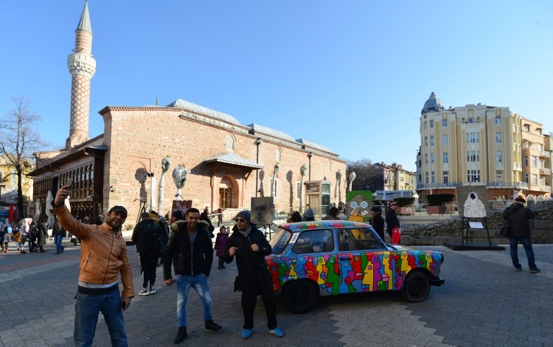 People take selfies with Trabant car exhibited as part of Art Liberte, the first traveling exhibition marking the occasion of the 30 years anniversary of fall of the Berlin wall in the town of Plovdiv, Bulgaria, Saturday, Jan. 12, 2019 (AP Photo)