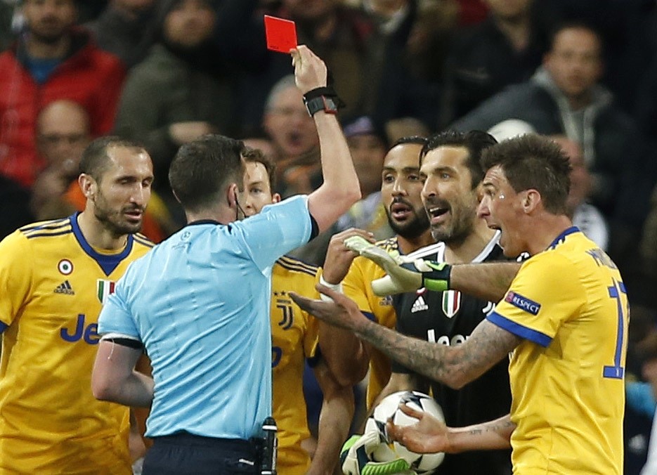 Referee Michael Oliver shows a red card to Juventus goalkeeper Gianluigi Buffon during a Champions League quarter final second leg match between Real Madrid and Juventus at the Santiago Bernabeu stadium, Madrid.