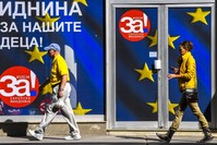 Macedonians pass an office of the coalition that supports the upcoming referendum, Skopje, Sept. 28.