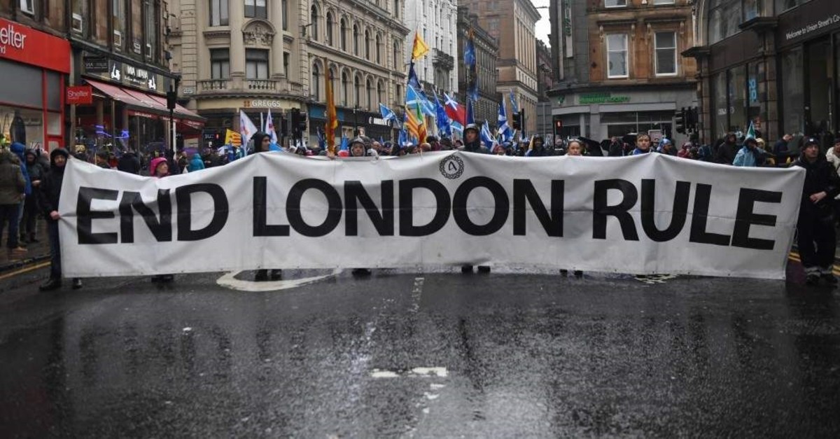 Pro-independence protesters hold up a long banner that reads ,End London Rule, during a march organized by the grassroots organization, All Under One Banner calling for Scottish independence, Glasgow, Jan. 11, 2020. Thousands of independence supporters are expected the march through the streets of Glasgow, despite a rally that was planned to conclude the event being cancelled after Met Office warnings of high winds. (Photo by ANDY BUCHANAN / AFP)