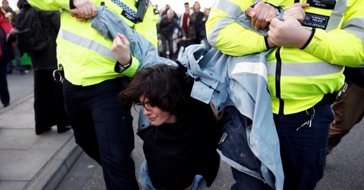 Police detain a protester as climate change activists demonstrate during a Extinction Rebellion protest at the Waterloo Bridge in London, Britain April 15, 2019. (Reuters Photo)