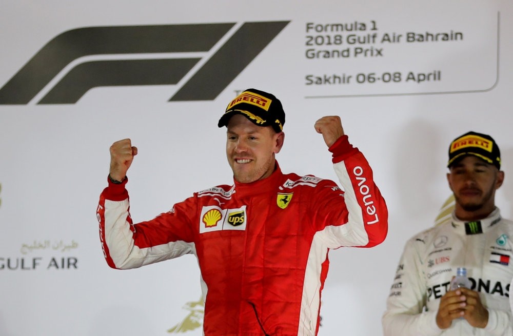 Ferrari's Sebastian Vettel celebrates winning the race as Mercedes' Lewis Hamilton looks on after Bahrain Grand Prix at Bahrain International Circuit, Sakhir, April 8.