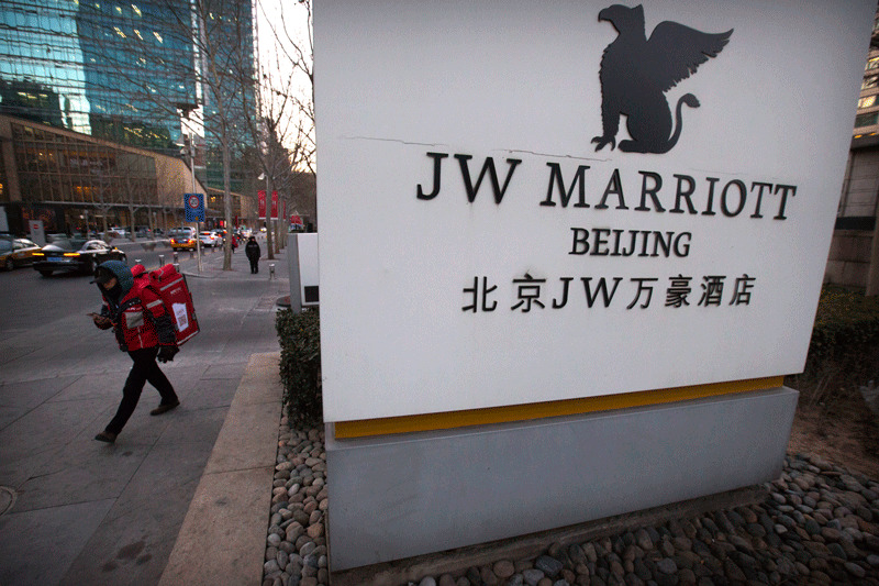 A deliveryman walks away from the entrance of a JW Marriott hotel in Beijing (AP Photo)