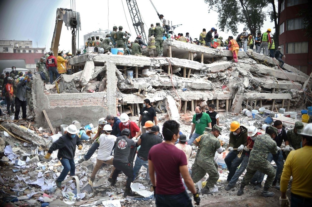 Rescuers, firefighters, policemen, soldiers and volunteers search for survivors in a flattened building in Mexico City on Sept. 20, a day after a strong quake hit central Mexico.