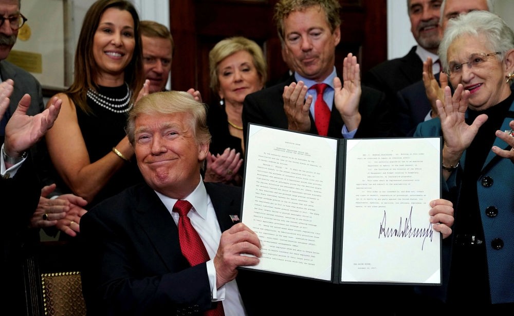 U.S. President Donald Trump smiles after signing an executive order at the White House in Washington, Oct. 12.