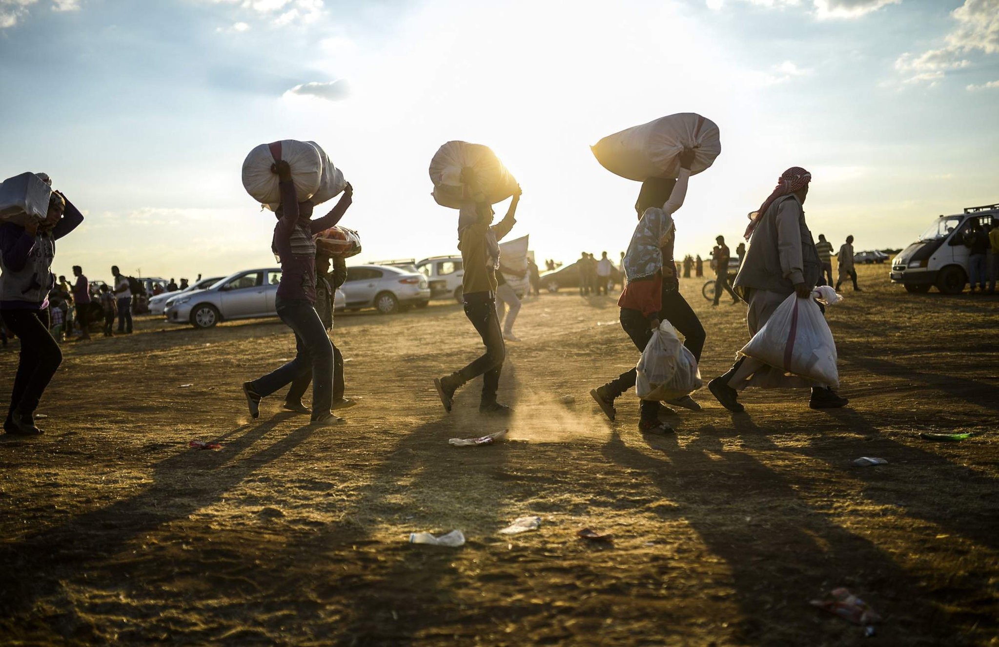 Syrian Kurds carry belongings as they cross the border between Syria and Turkey near the southeastern town of Suruu00e7 in u015eanlu0131urfa province, on September 20, 2014.