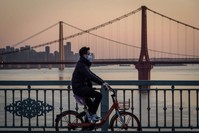 A man wearing a protective face mask rides a bicycle in Wuhan in China's central Hubei province, Feb. 17, 2020. (AFP Photo)