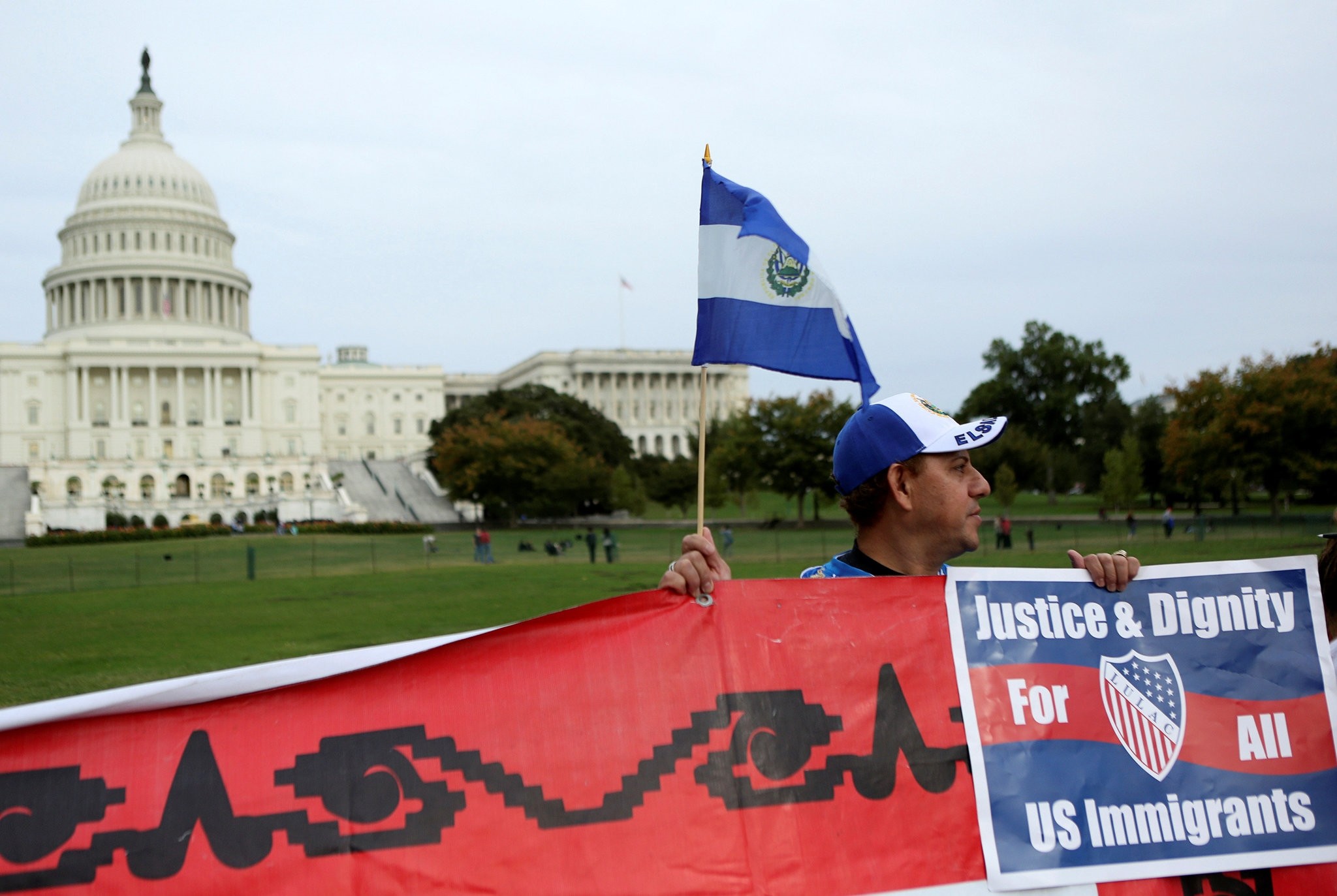 A Salvadoran man holds his nation's flag and a sign during a protest rally for immigrants rights on Capitol Hill in Washington, DC, U.S., October 8, 2013.     (REUTERS Photo)