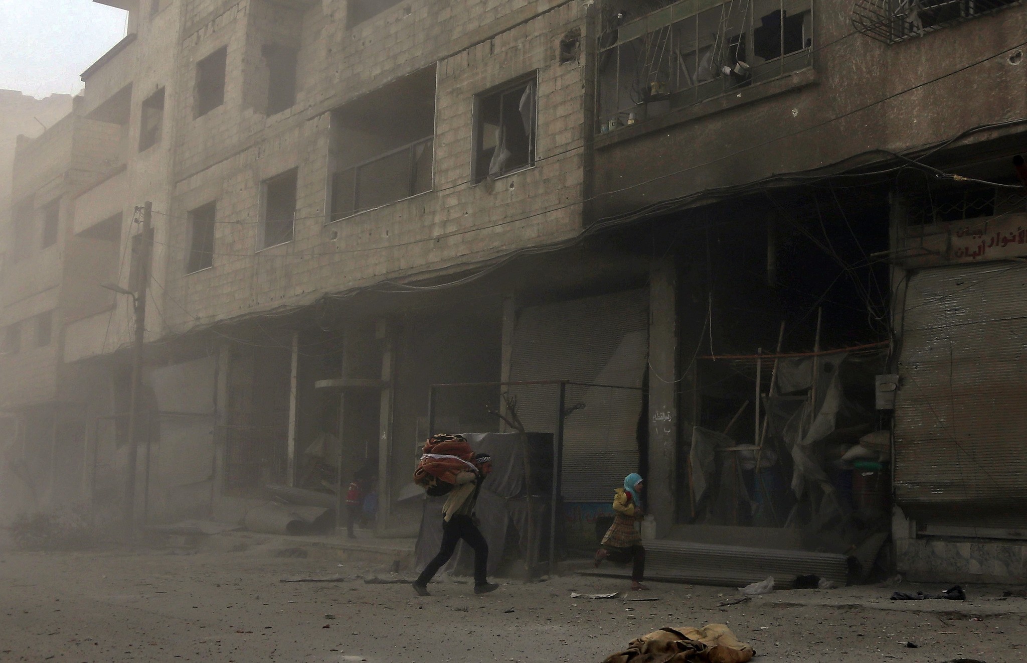 Syrians run from cover in Hamouria during regime shelling in the Eastern Ghouta suburb of Damascus, March 6.